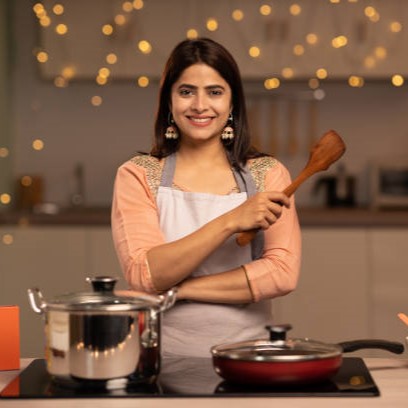 Portrait of a young woman cooking food in the kitchen